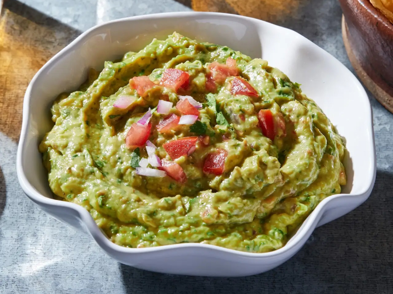 A bowl of fresh guacamole.  A bowl of fresh guacamole.