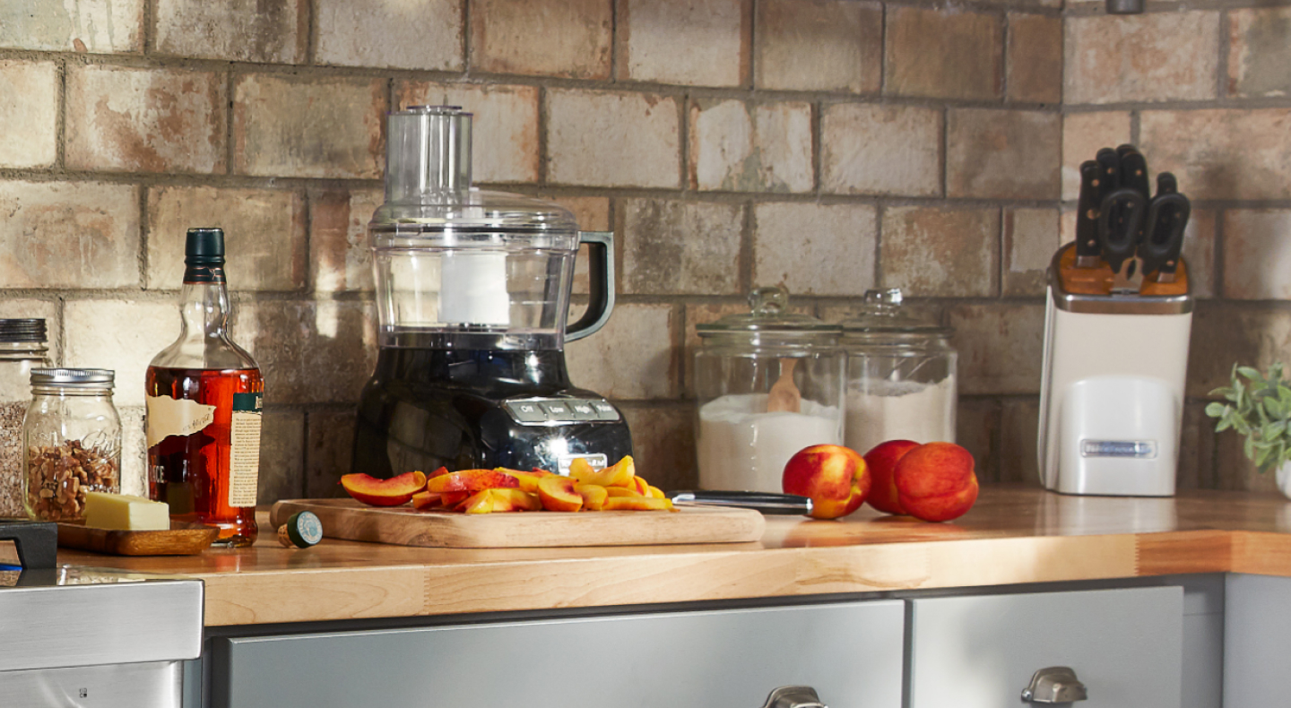 Sliced peaches on counter with ingredients and food processor Sliced peaches on counter with ingredients and food processor