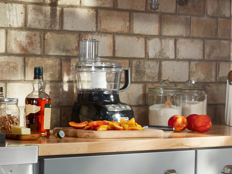 Sliced peaches on counter with ingredients and food processor Sliced peaches on counter with ingredients and food processor