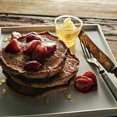 Homemade pancakes on tray topped with fresh strawberries