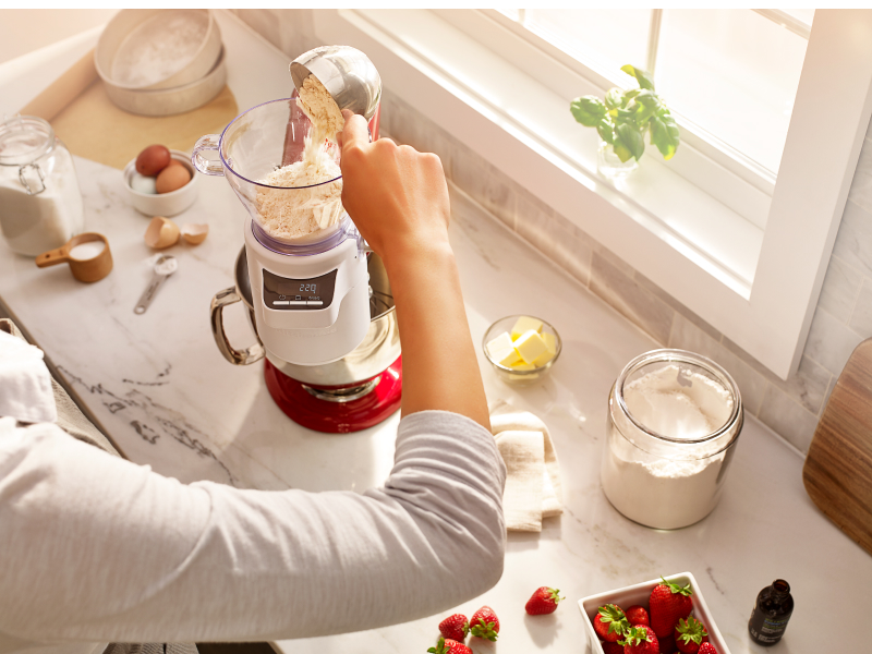 Person measuring flour in KitchenAid® Sifter + Scale Attachment Person measuring flour in KitchenAid® Sifter + Scale Attachment