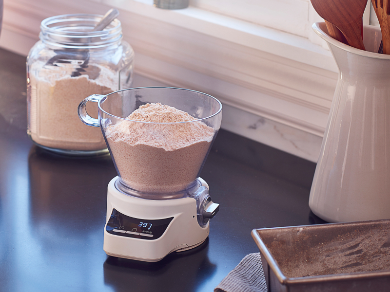 KitchenAid® Sifter + Scale Attachment sitting on countertop full of flour KitchenAid® Sifter + Scale Attachment sitting on countertop full of flour