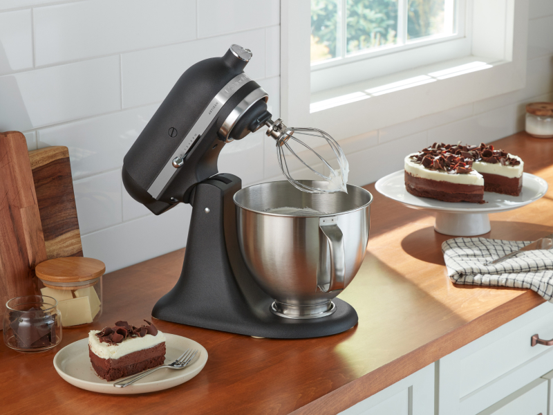 KitchenAid® stand mixer with wire whip next to cake KitchenAid® stand mixer with wire whip next to cake