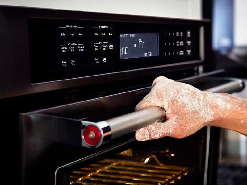 A person holding opening an oven