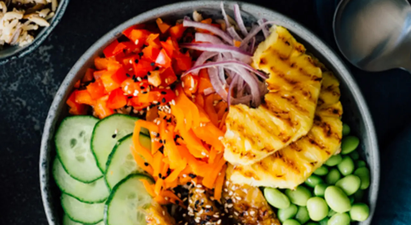 Birds-eye view of a poke bowl with red onion, tomato, cucumber and more Birds-eye view of a poke bowl with red onion, tomato, cucumber and more
