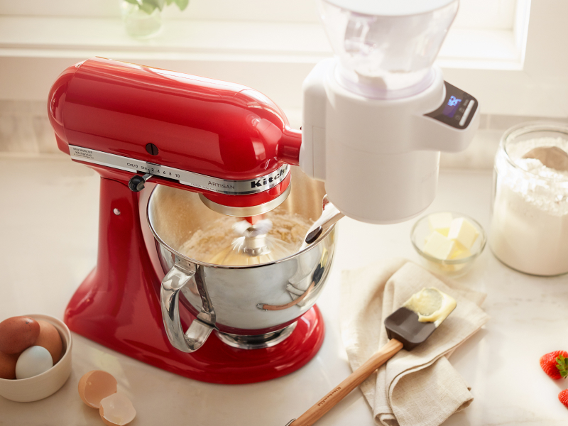 A red KitchenAid® stand mixer amongst various baking ingredients A red KitchenAid® stand mixer amongst various baking ingredients