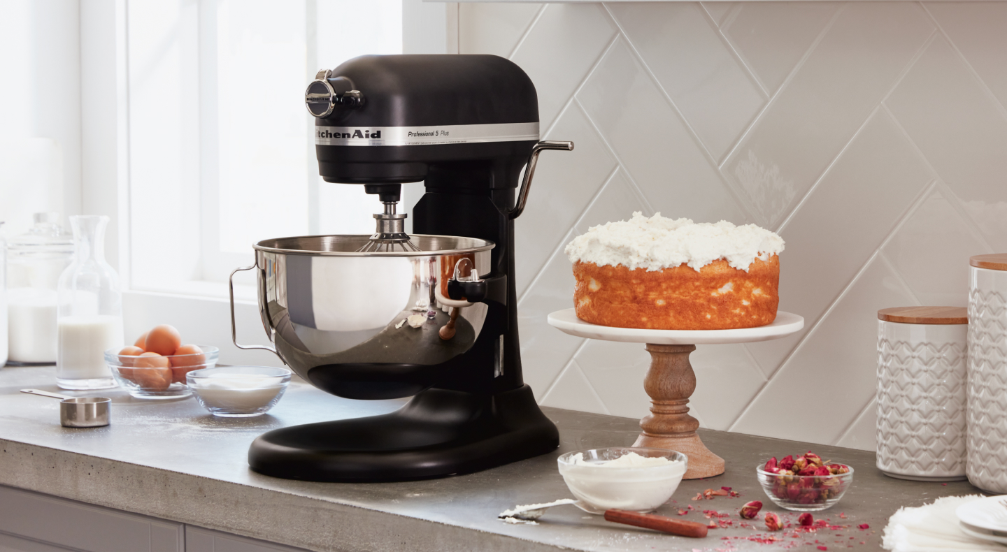 A black KitchenAid® stand mixer next to a cake A black KitchenAid® stand mixer next to a cake