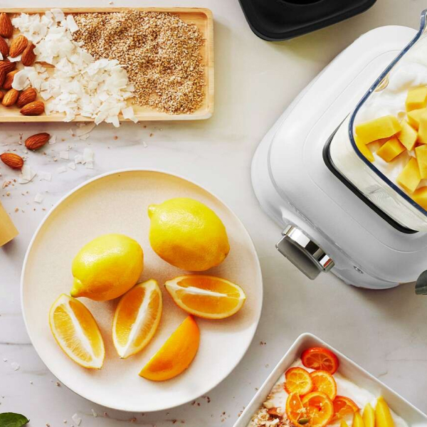 Sliced citrus on a plate next to a KitchenAid® blender