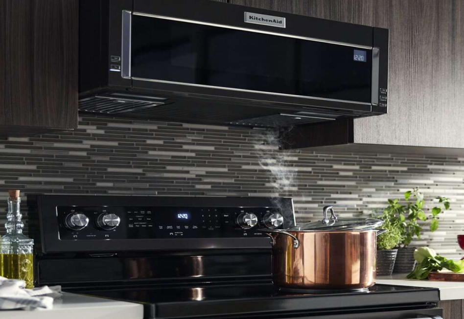 Pot of water with lid half-on boiling water on electric cooktop Pot of water with lid half-on boiling water on electric cooktop