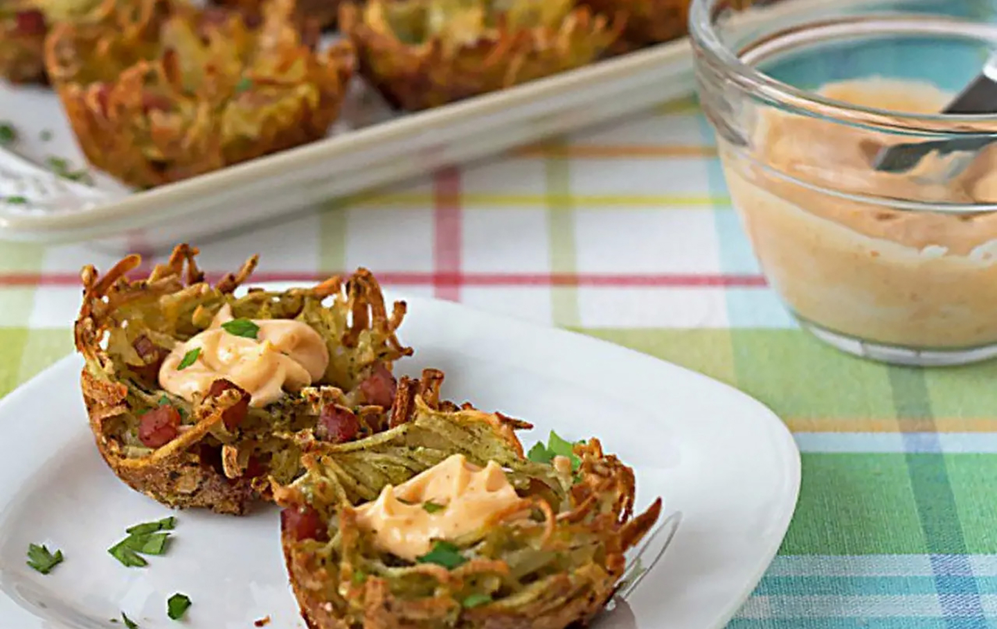 A plate of potato vegetable fritters with an aioli sauce A plate of potato vegetable fritters with an aioli sauce