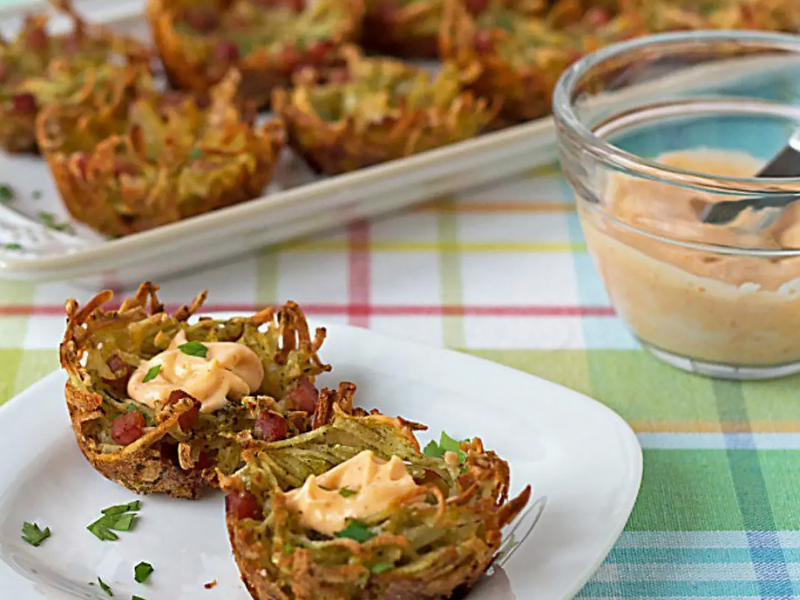 A plate of potato vegetable fritters with an aioli sauce A plate of potato vegetable fritters with an aioli sauce