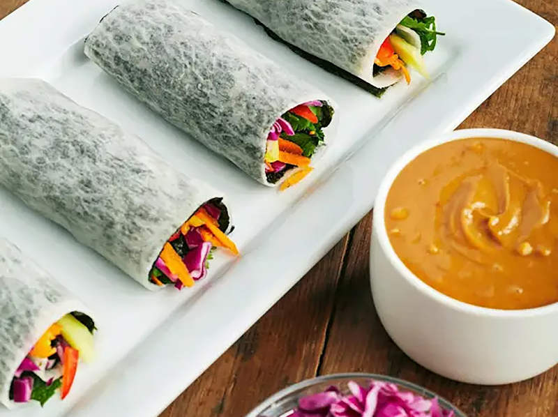 Rainbow spring rolls with shredded cabbage and peanut dipping sauce Rainbow spring rolls with shredded cabbage and peanut dipping sauce
