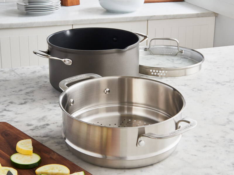 A pot with a metal steaming basket A pot with a metal steaming basket