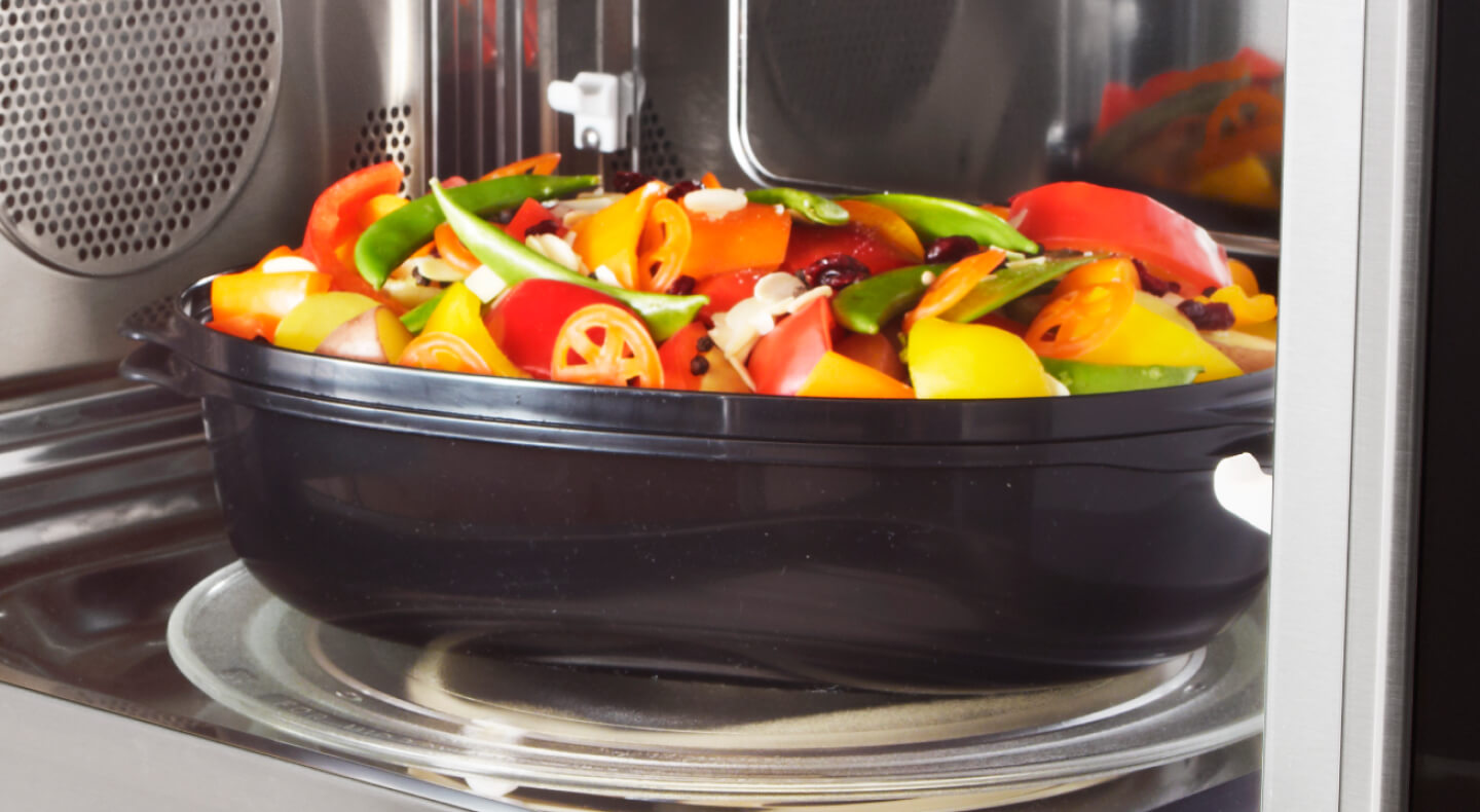 Vegetables in a container in a microwave Vegetables in a container in a microwave