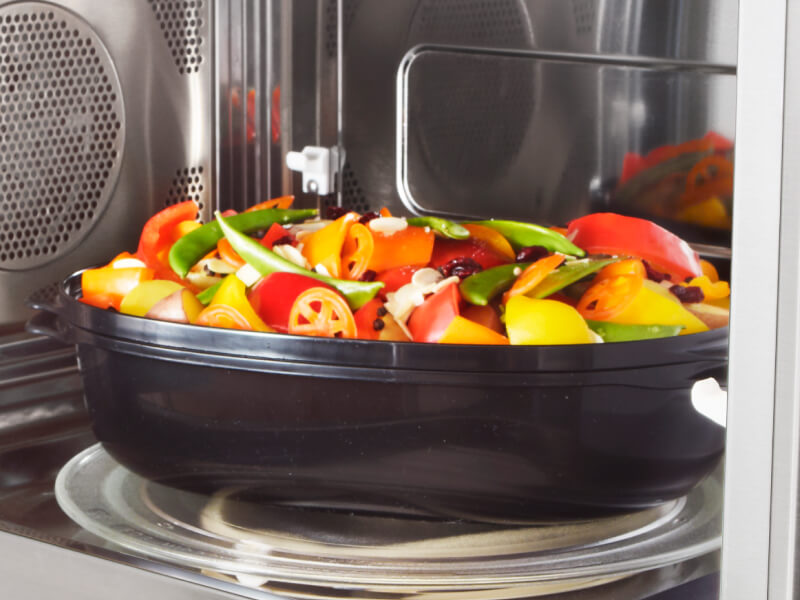 Vegetables in a container in a microwave