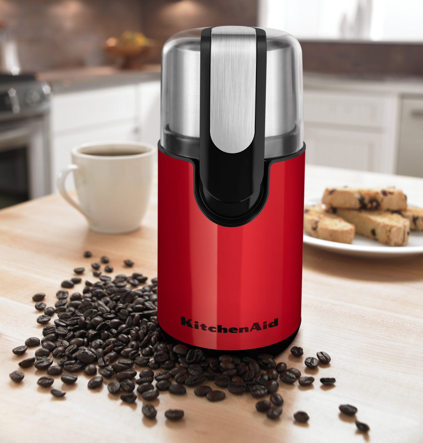 Red coffee grinder on a countertop with beans Red coffee grinder on a countertop with beans