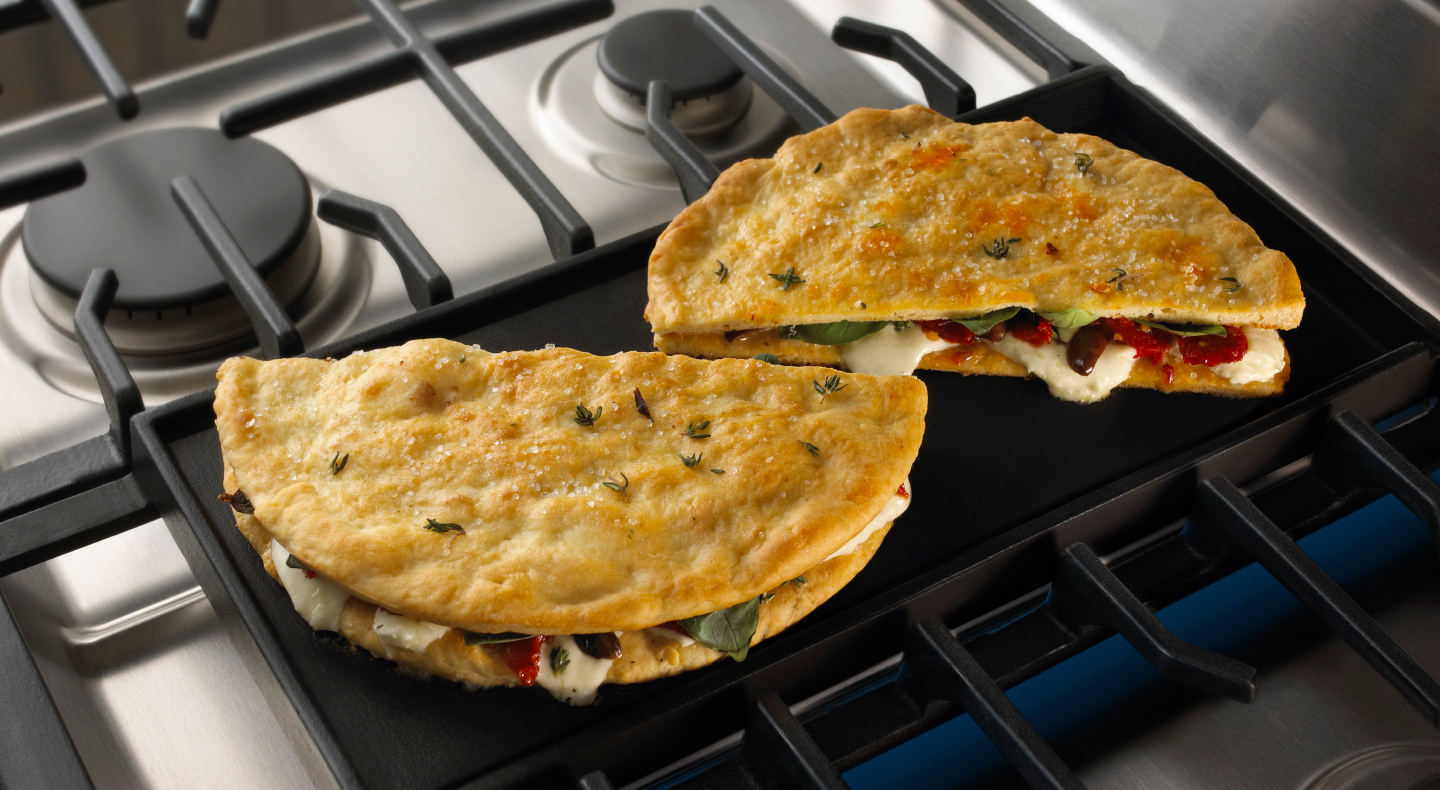 Stuffed pita breads cooking on a gas stove griddle Stuffed pita breads cooking on a gas stove griddle