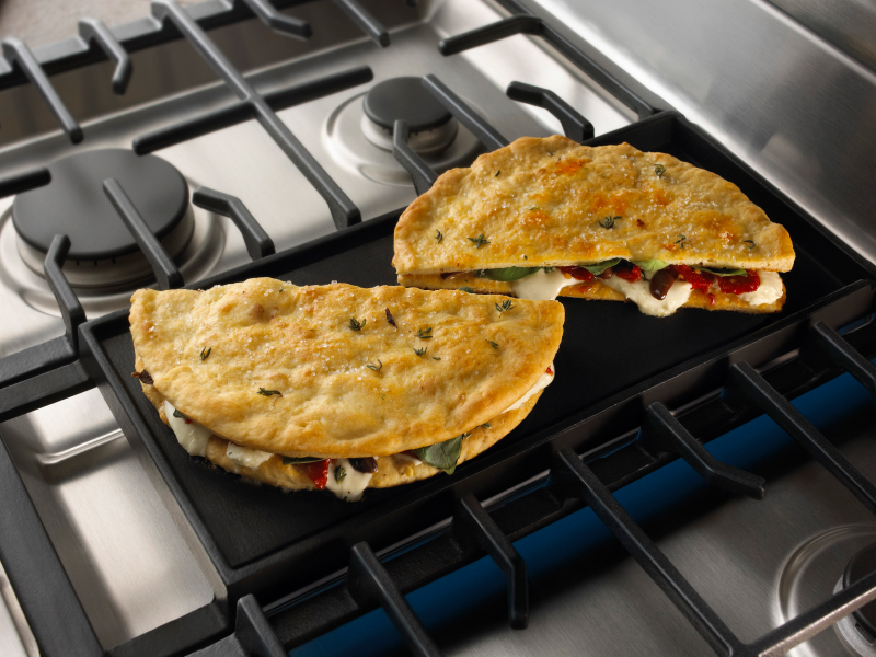 Stuffed pita breads cooking on a gas stove griddle Stuffed pita breads cooking on a gas stove griddle