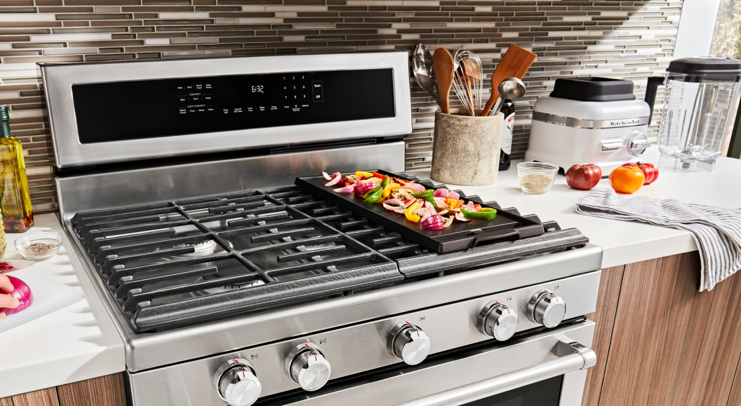 Various ingredients cooking on a gas stove griddle Various ingredients cooking on a gas stove griddle