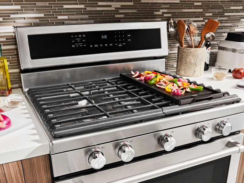 Various ingredients cooking on a gas stove griddle Various ingredients cooking on a gas stove griddle