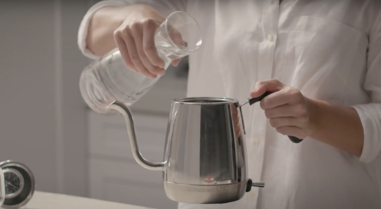 Maker pouring water into stainless steel KitchenAid® gooseneck kettle Maker pouring water into stainless steel KitchenAid® gooseneck kettle