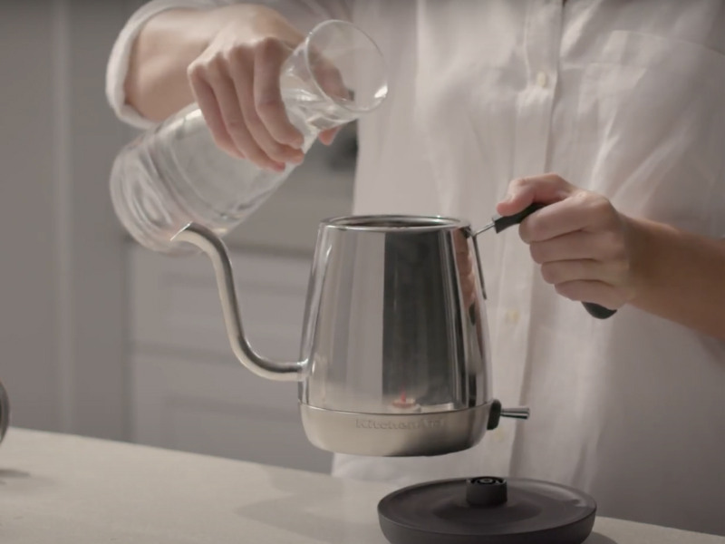 Maker pouring water into stainless steel KitchenAid® gooseneck kettle Maker pouring water into stainless steel KitchenAid® gooseneck kettle