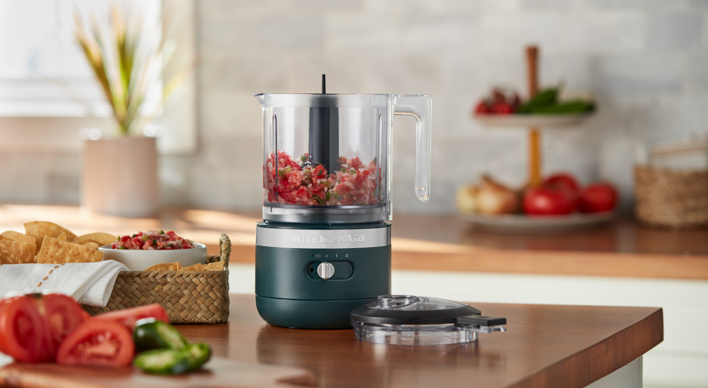 Gray food chopper filled with prepared Pico de Gallo