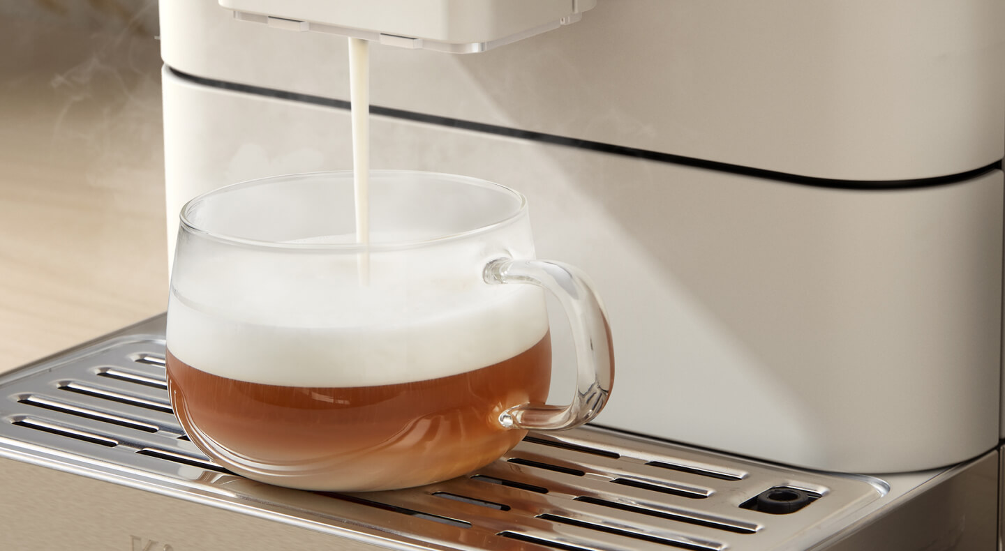 Frothed milk being poured over an espresso beverage Frothed milk being poured over an espresso beverage