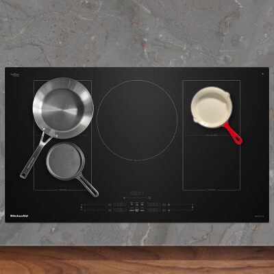 An induction cooktop with three pans on it An induction cooktop with three pans on it