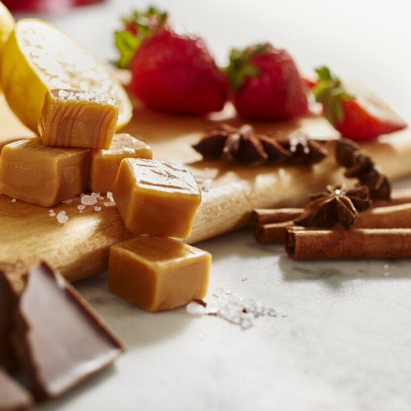 Caramel, chocolate and strawberries on a cutting board