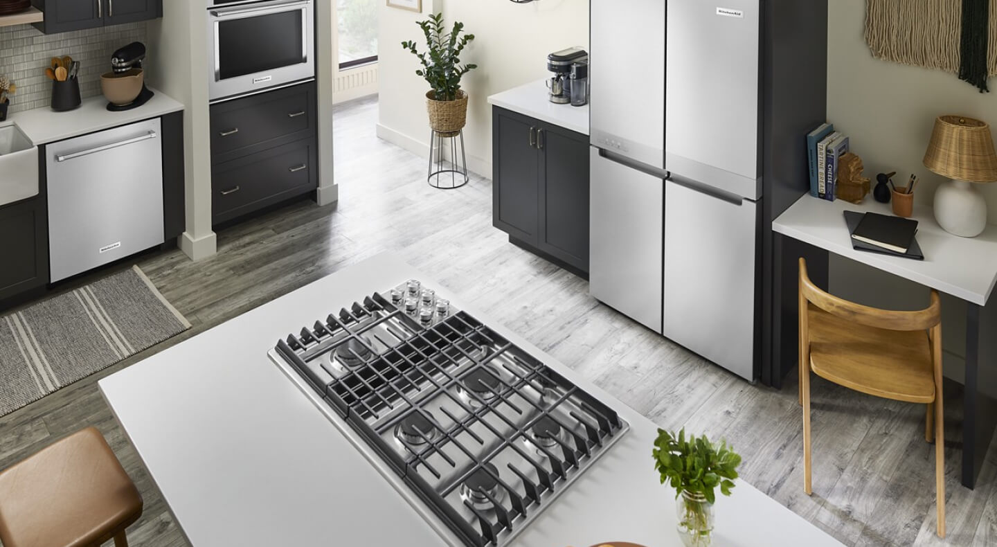 A bright kitchen with an island with a cooktop installed in it A bright kitchen with an island with a cooktop installed in it