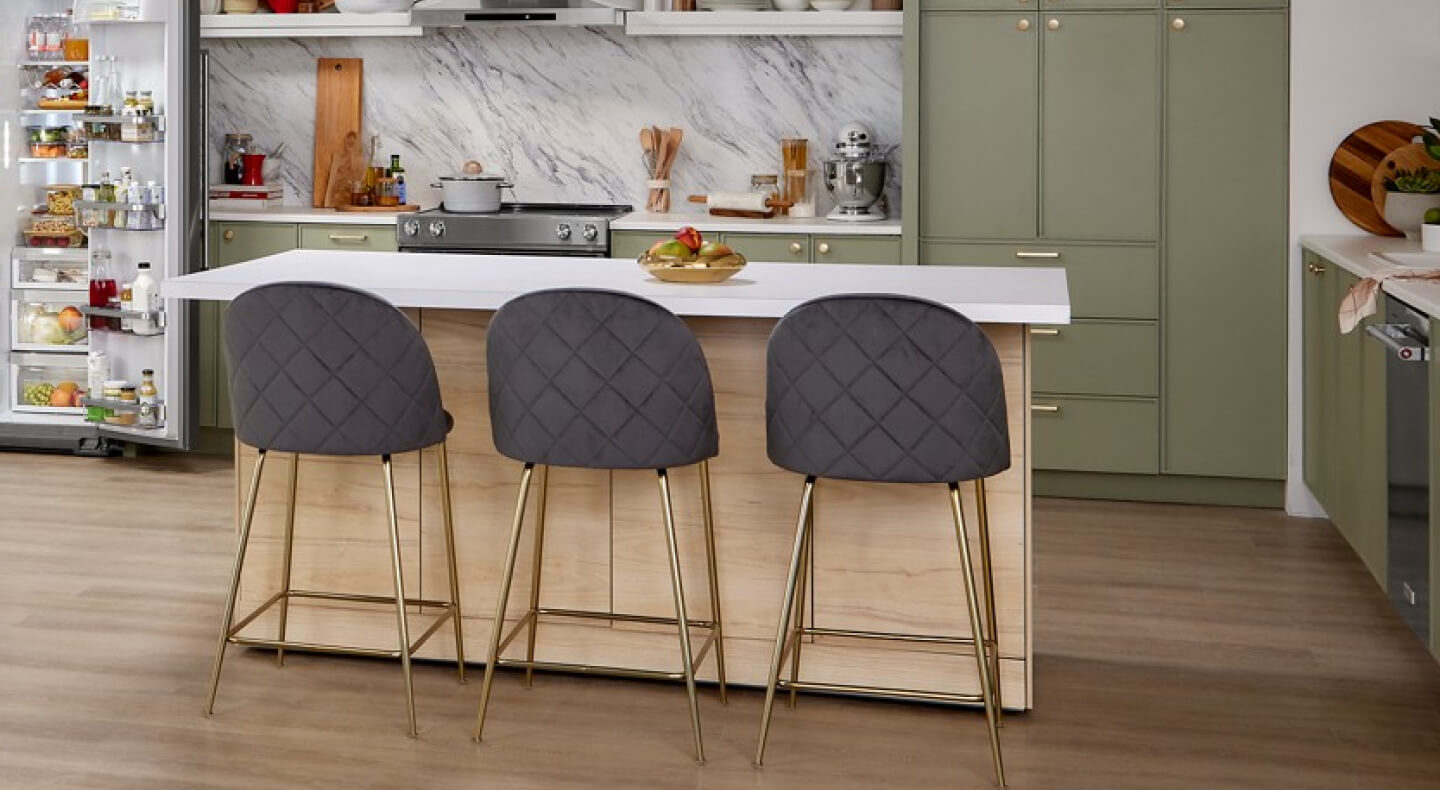 A white-topped kitchen island with three stools A white-topped kitchen island with three stools