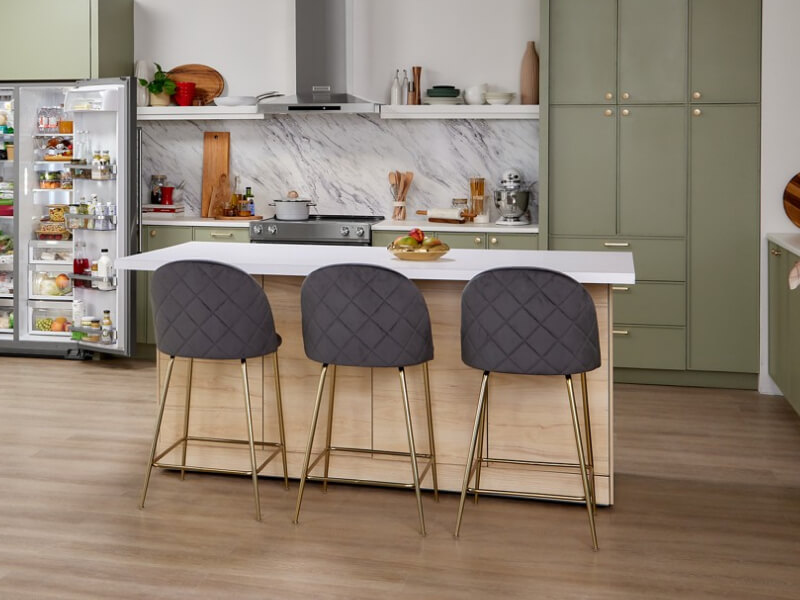 A white-topped kitchen island with three stools A white-topped kitchen island with three stools