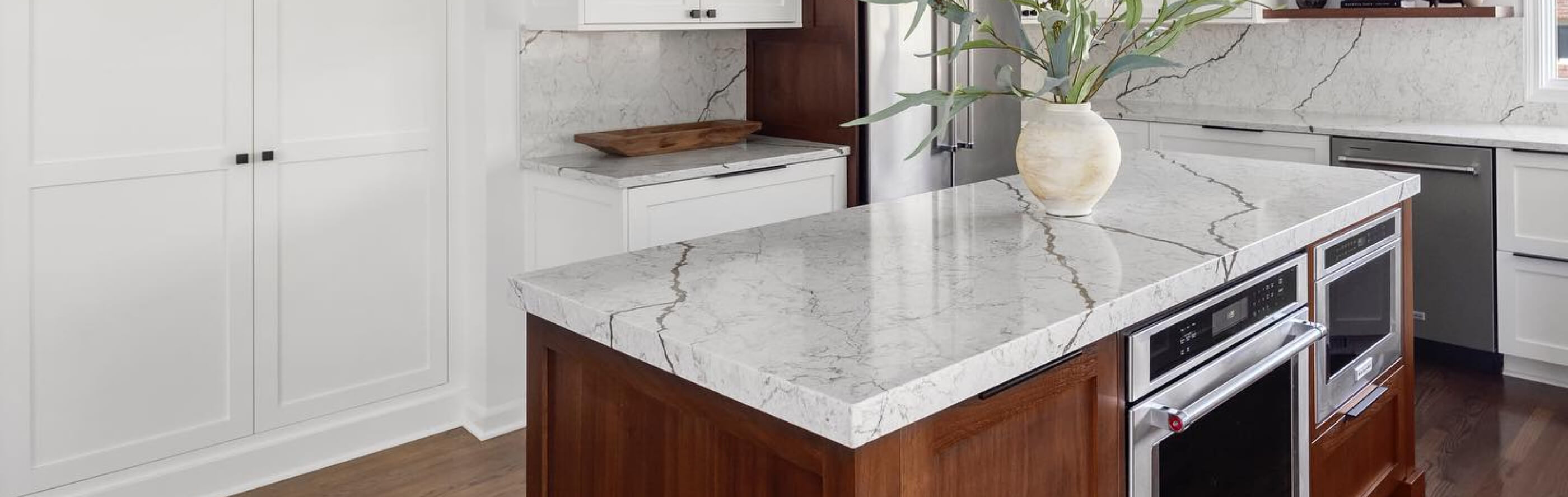 A bright kitchen with a white, marble-like island