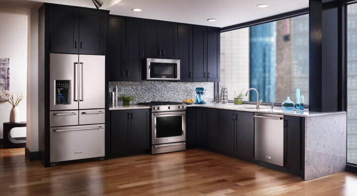A modern kitchen with dark cabinets and stainless steel appliances