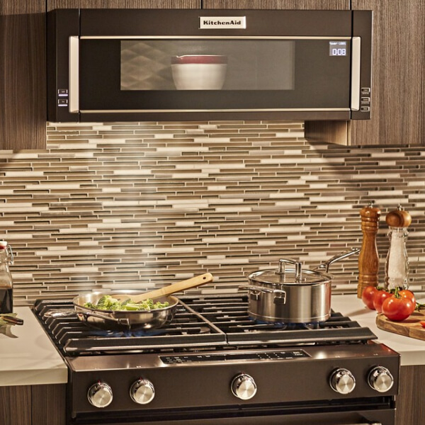 Dish heating in a black stainless, KitchenAid® low profile microwave above stovetop