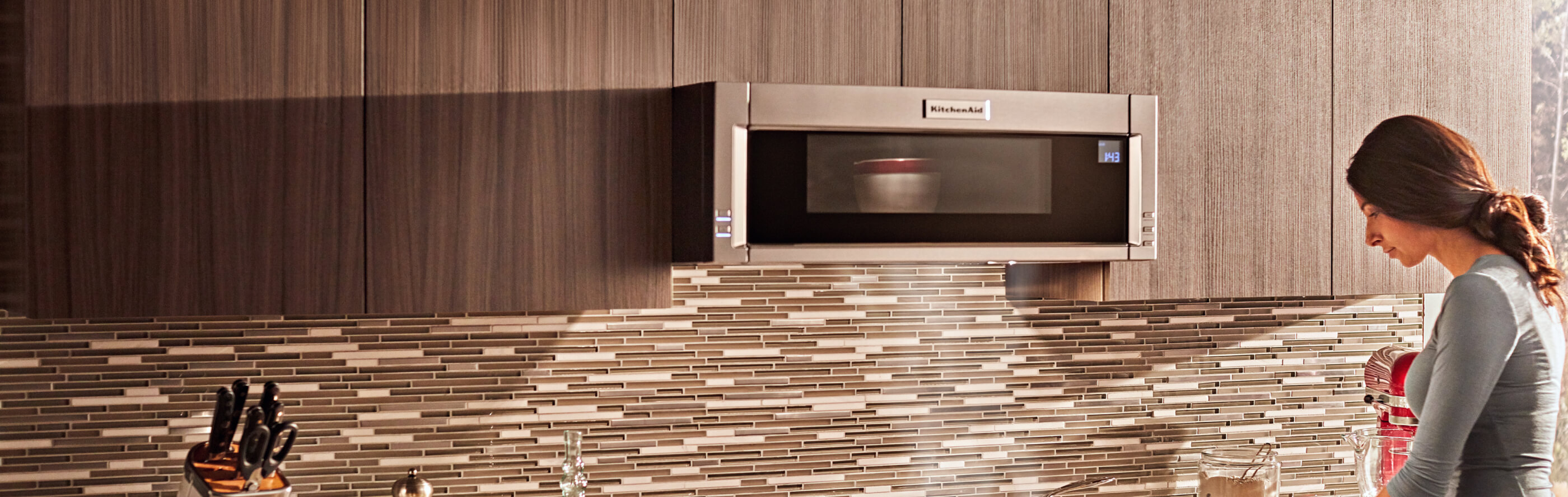 Person heating up food in a KitchenAid® microwave