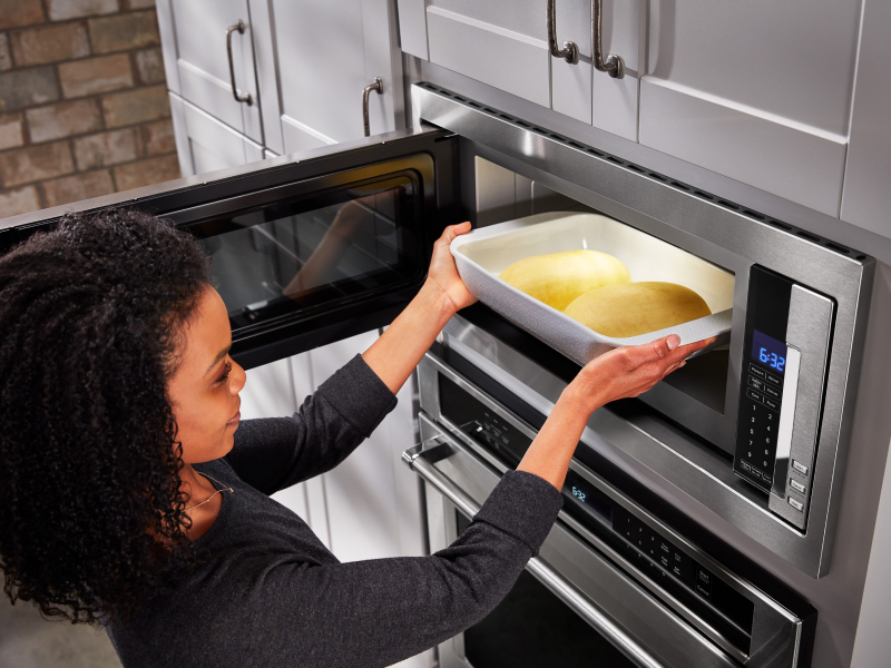 Person putting food into microwave Person putting food into microwave