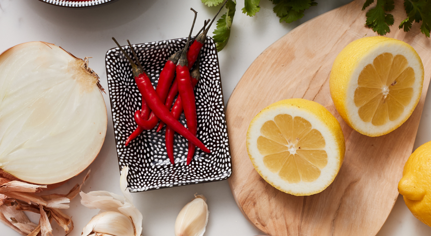 Onions, Chili peppers and lemon on table Onions, Chili peppers and lemon on table