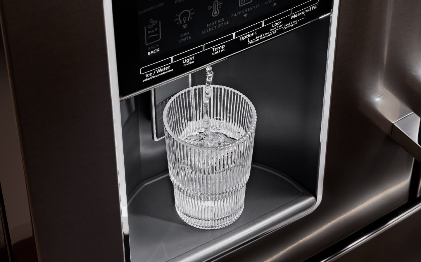 A glass of water filling up at a refrigerator’s exterior ice and water dispenser A glass of water filling up at a refrigerator’s exterior ice and water dispenser