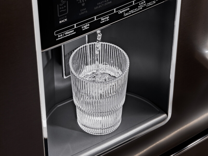 A glass of water filling up at a refrigerator’s exterior ice and water dispenser A glass of water filling up at a refrigerator’s exterior ice and water dispenser