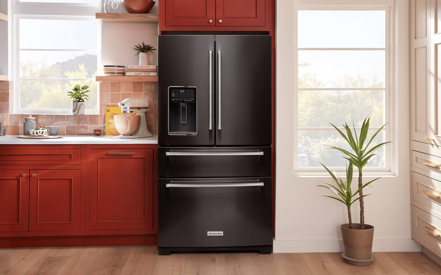 A black stainless KitchenAid® multi-door French-door refrigerator in a bright kitchen