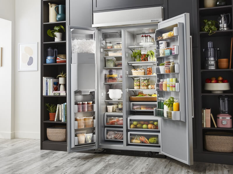 An open side-by-side refrigerator, full of colorful food items An open side-by-side refrigerator, full of colorful food items