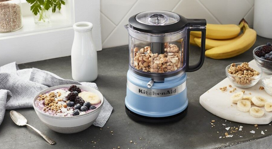 Blue food processor filled with nuts Blue food processor filled with nuts