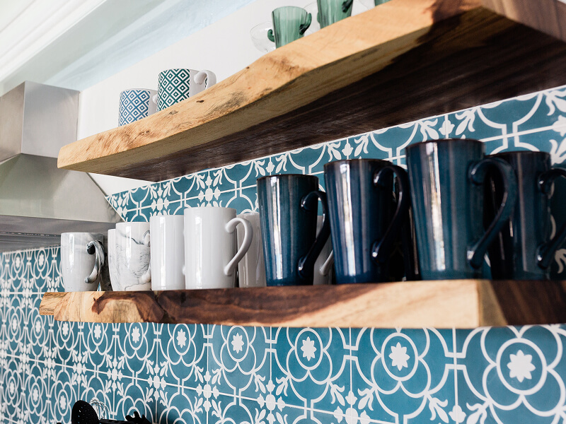 Mugs on floating wood shelves installed on a patterned wall Mugs on floating wood shelves installed on a patterned wall
