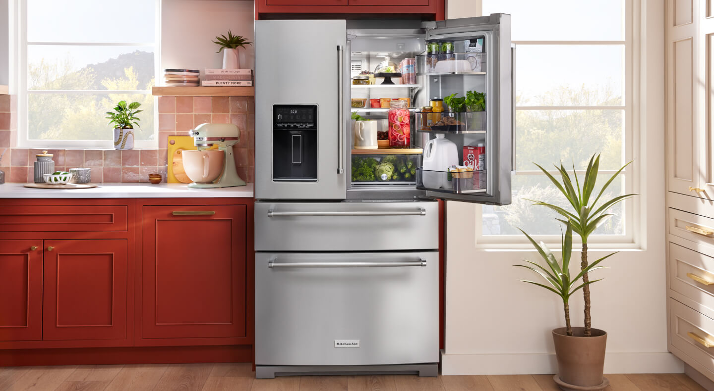 KitchenAid® multi-door refrigerator with one door open and stocked with fresh foods