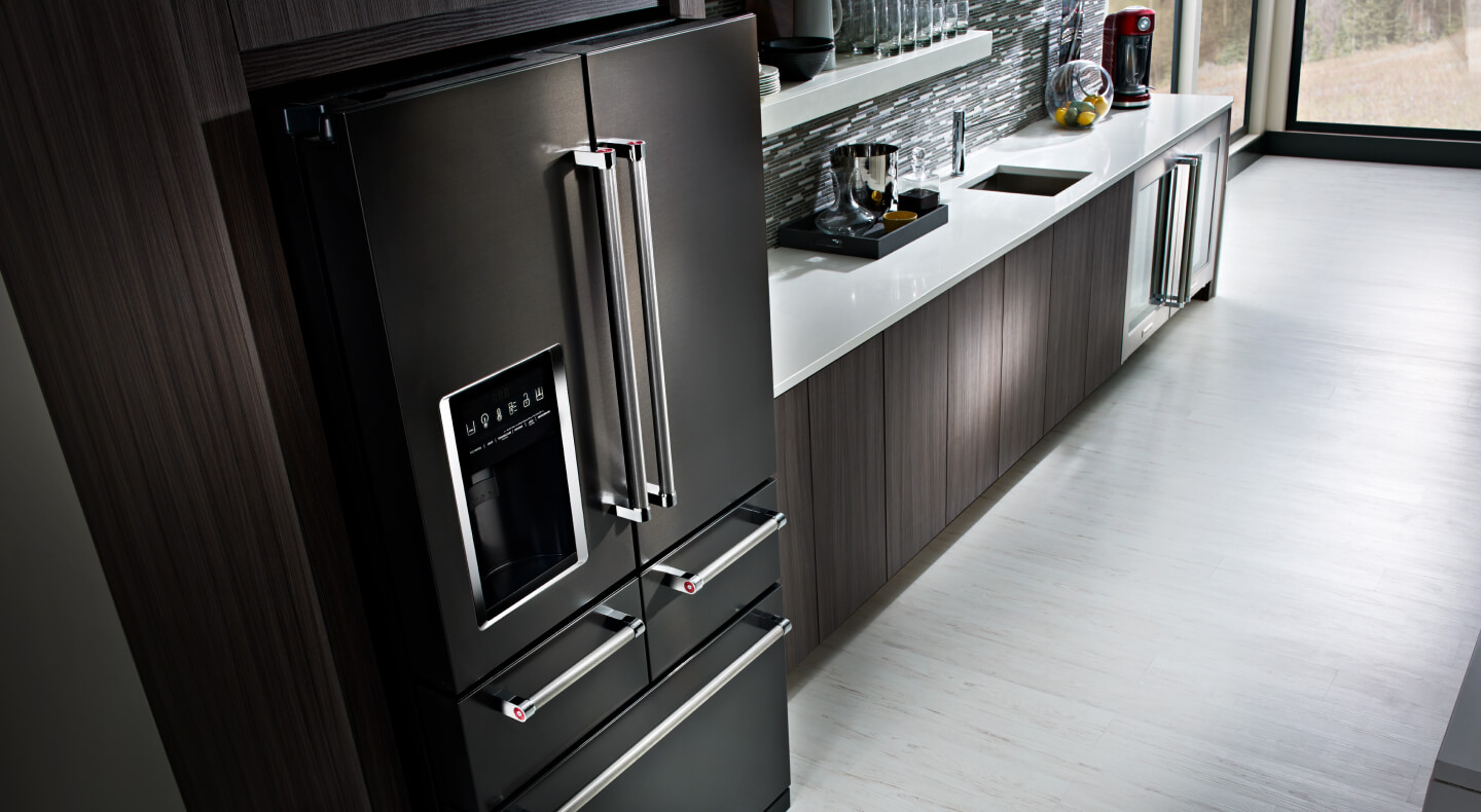 Black stainless steel KitchenAid® multi-door refrigerator in dark cabinetry