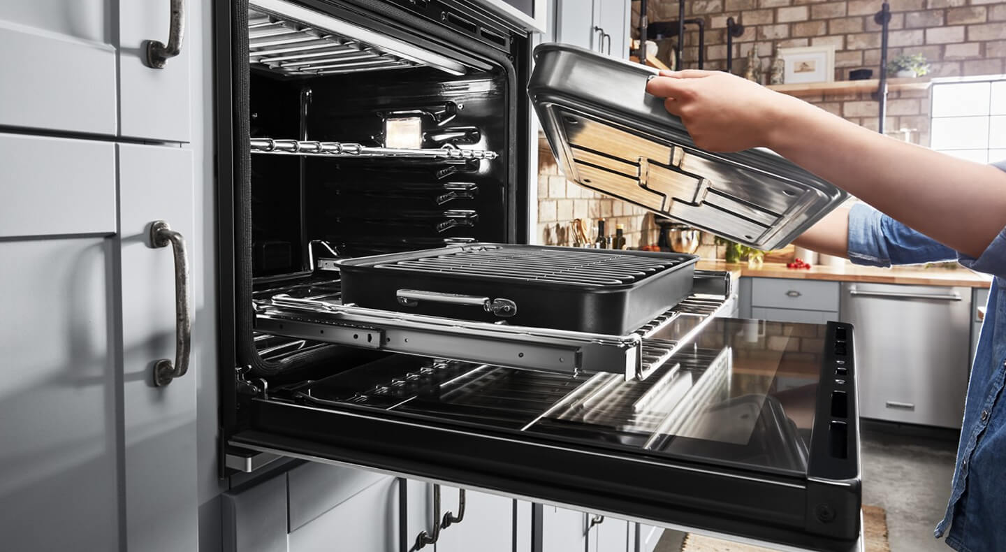 Person removing pans from an oven