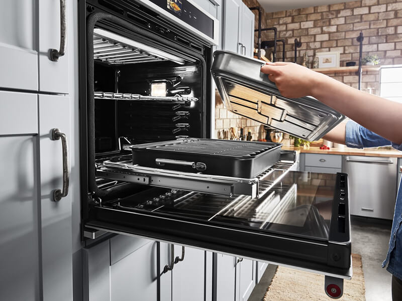 Person removing pans from an oven