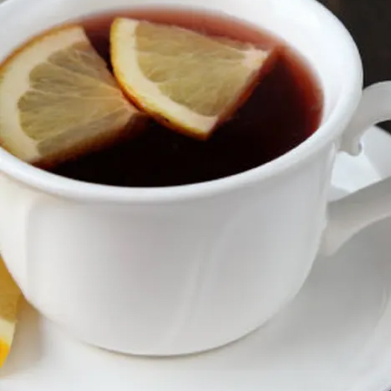 Cup of tea topped with two lemon wedges